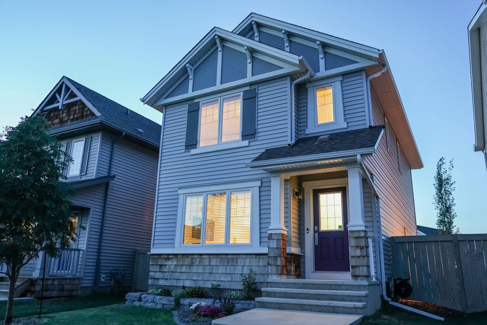 Modern home exterior with new siding and windows at dusk